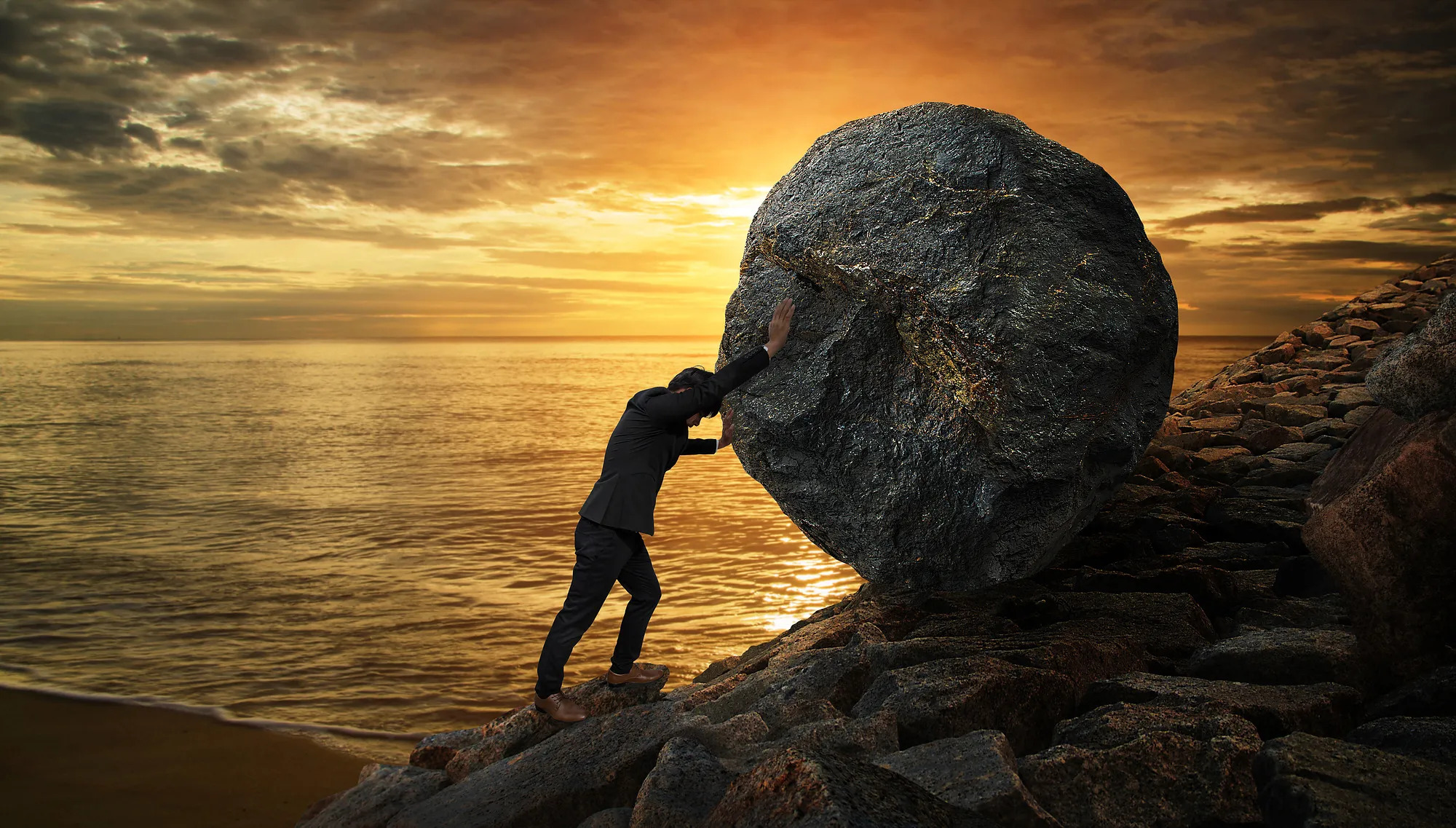 Man pushing boulder up hill